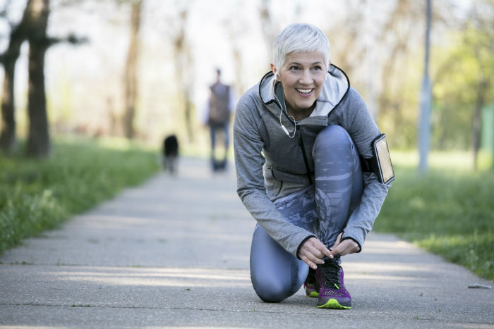 A mature woman stops for a rest during a run