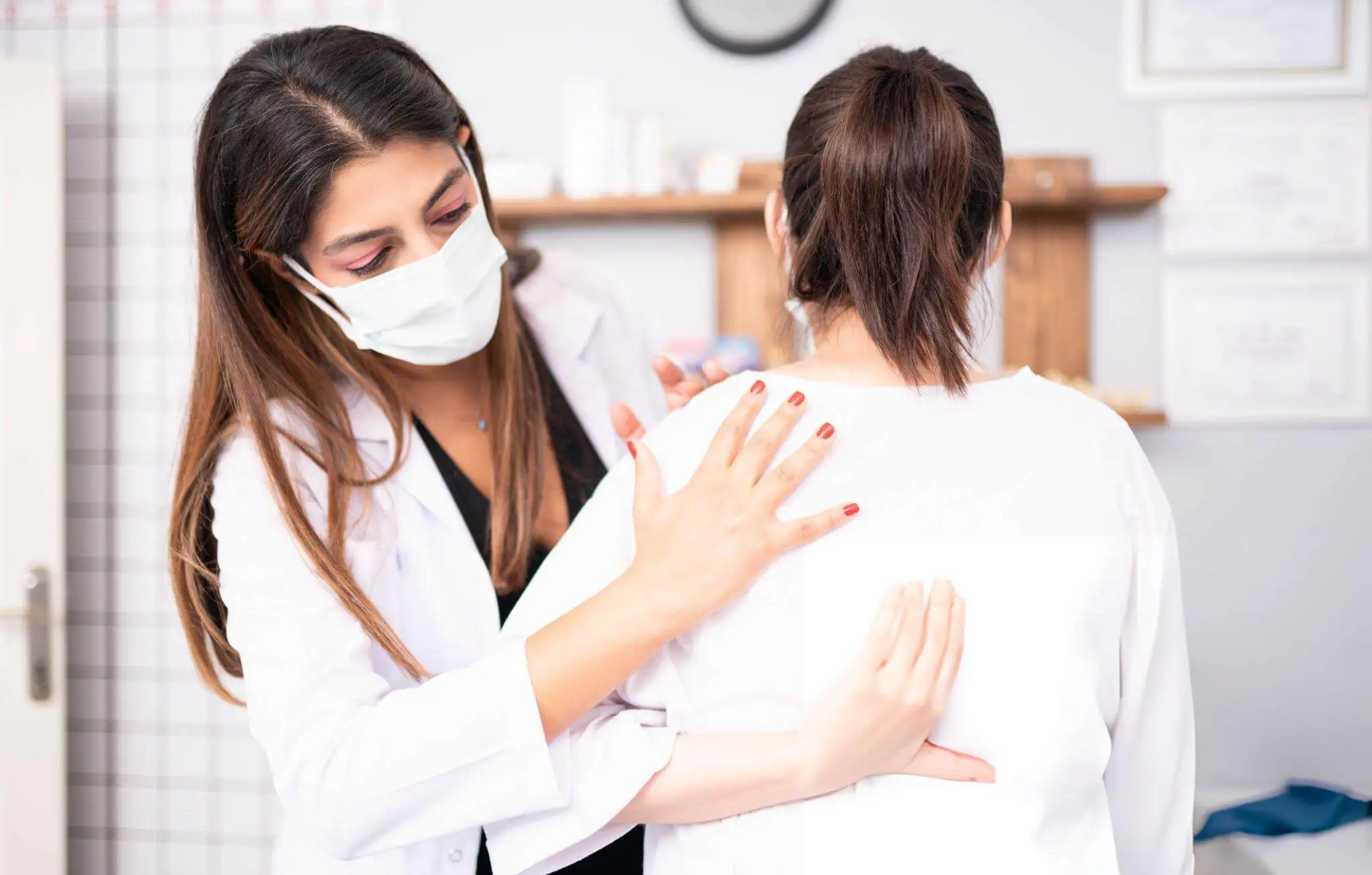 Medical professional assessing a patient’s shoulder to determine conservative treatment options for rotator cuff disease.