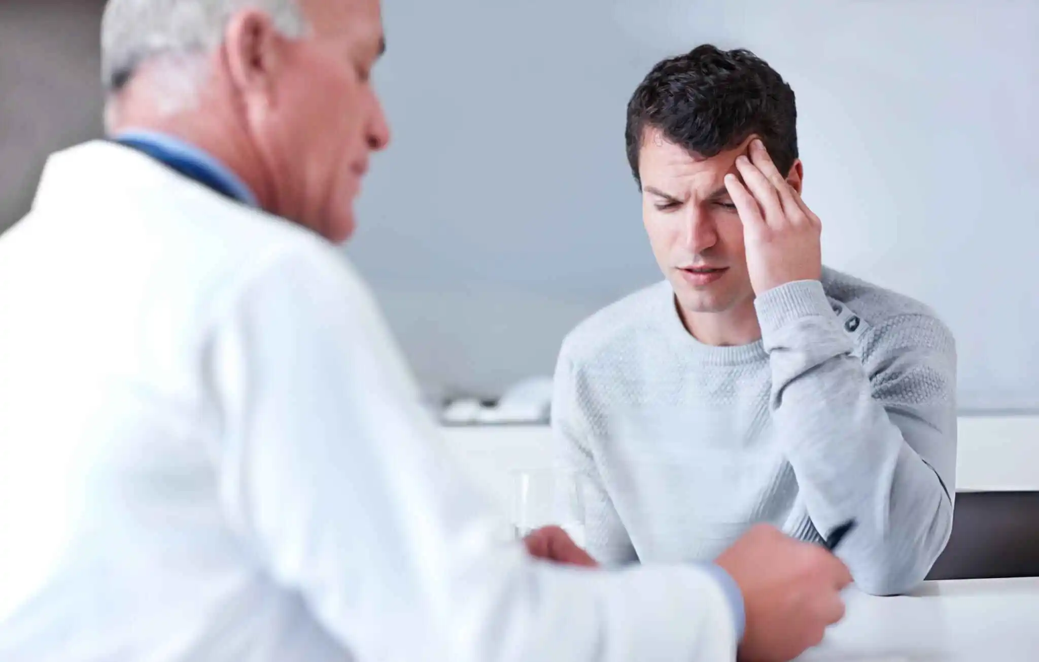 Two individuals in a clinical setting engaged in a discussion, symbolizing the consultation process regarding the advantages of donor stem cells over autologous options.
