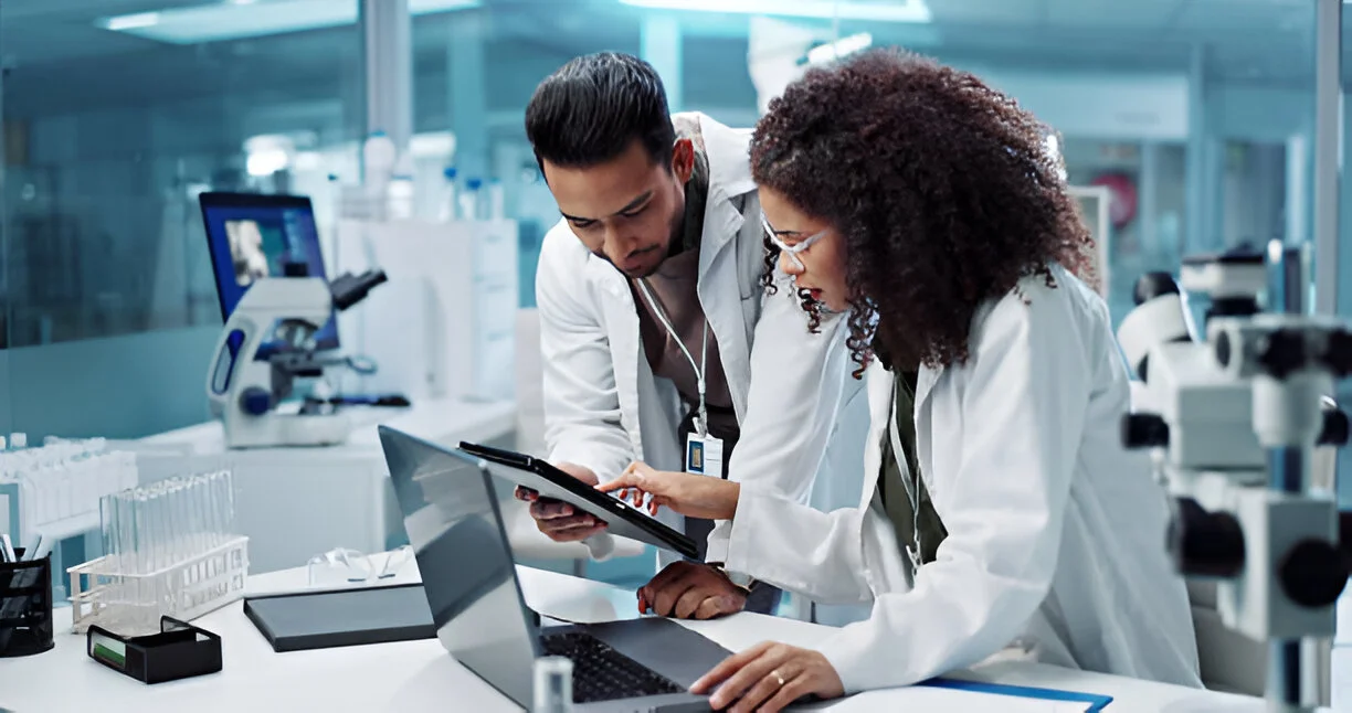 Medical researchers discussing findings in a modern lab setting, surrounded by laboratory equipment, symbolizing collaborative research and advancements in stem cell therapy for Lyme disease.