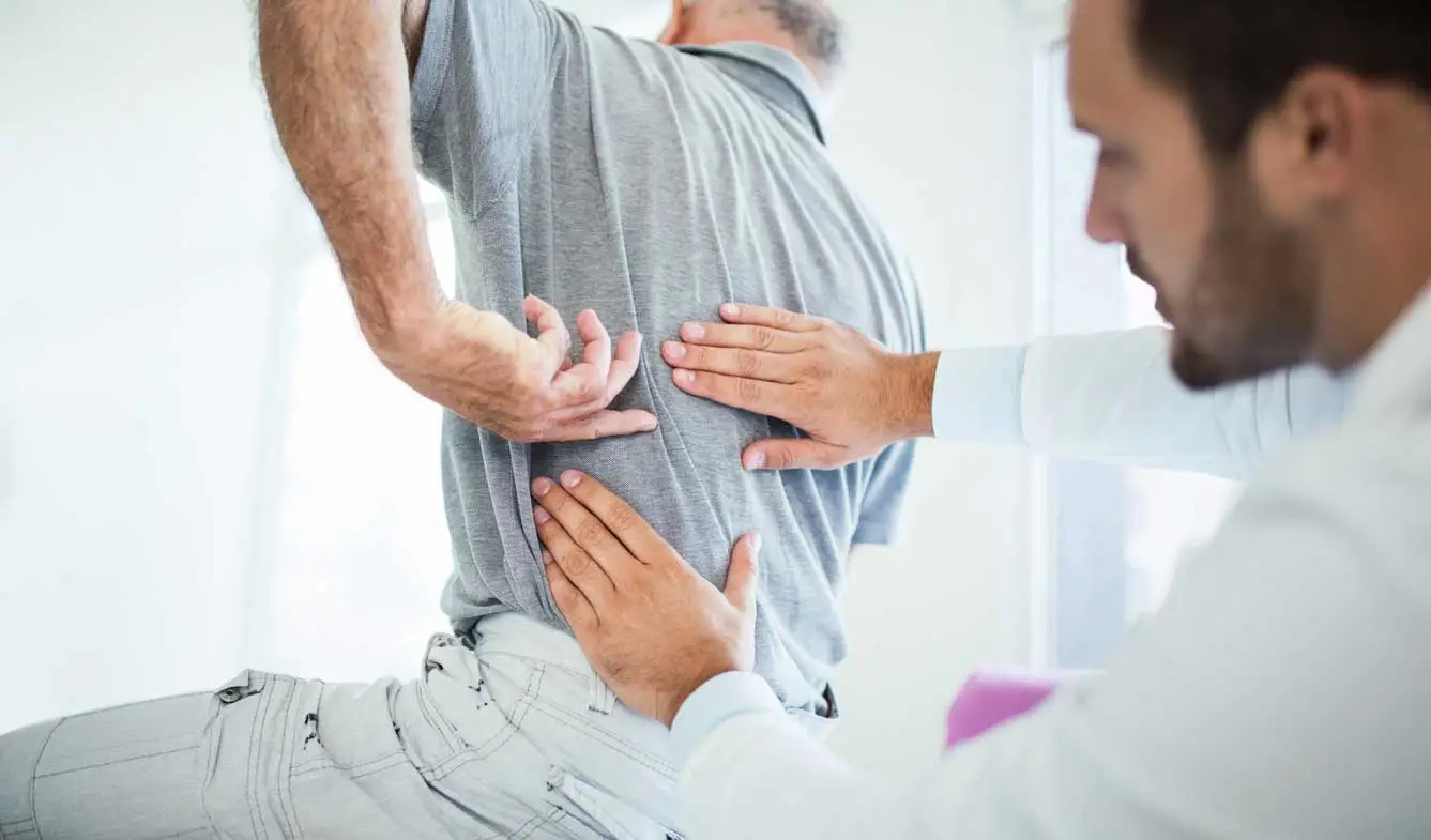 doctor-examining-patient-lower-back-pain-liberty-lake