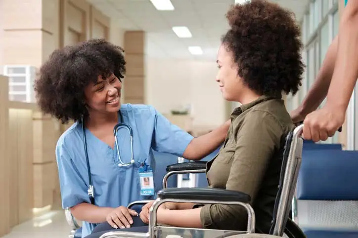 A doctor providing comprehensive and compassionate care to a young patient in a wheelchair.