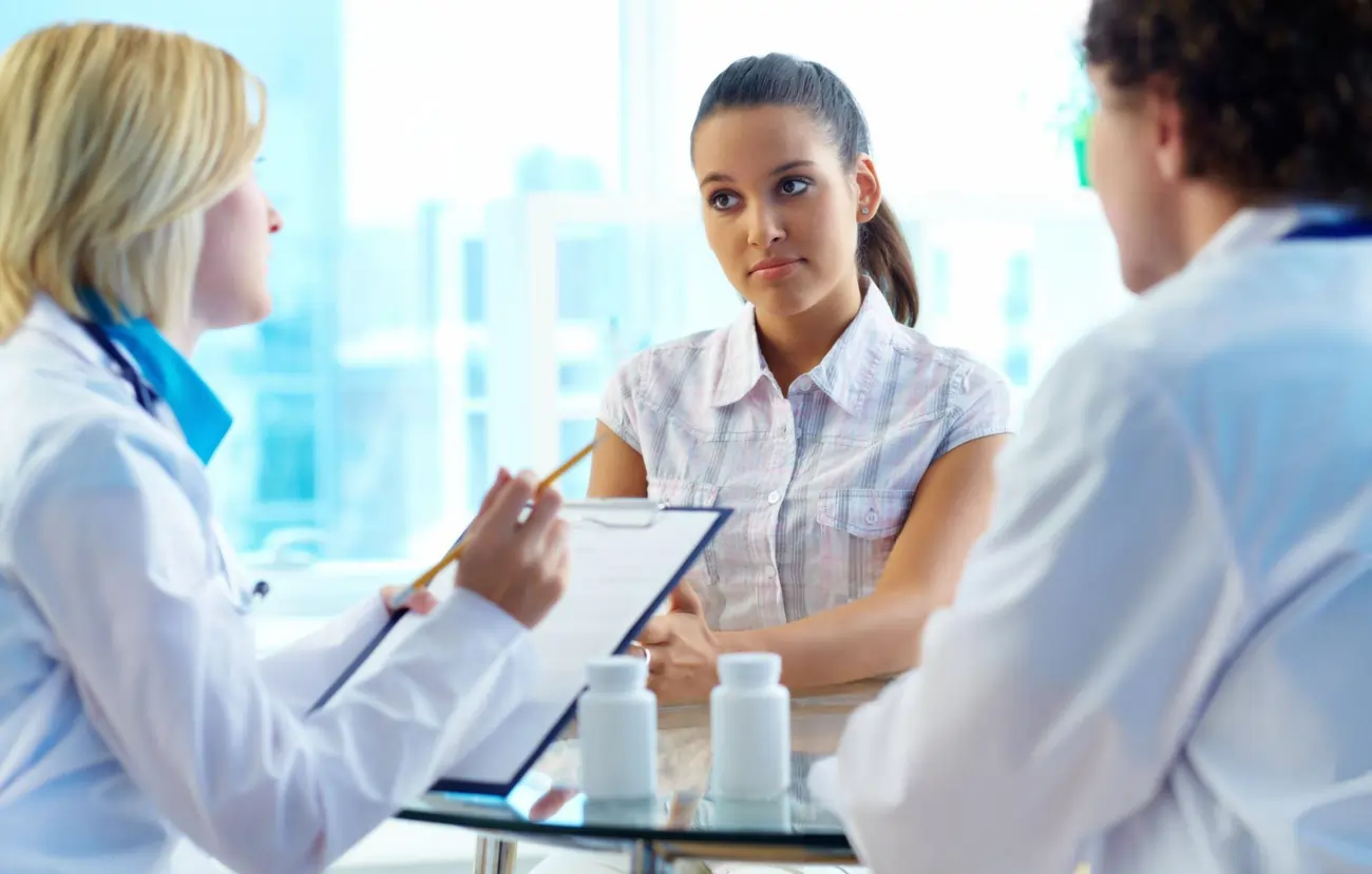 A woman consults with two doctors, discussing her health options and potential treatments.