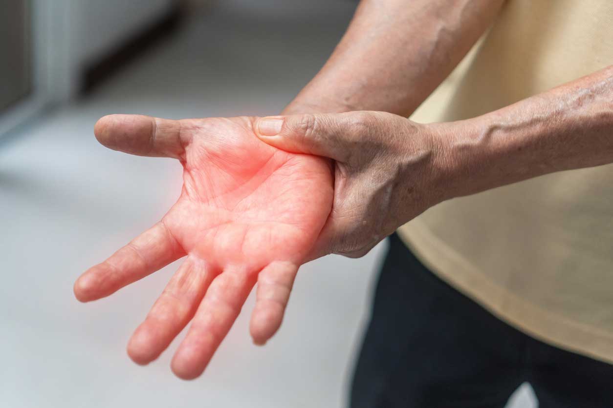 Person experiencing neuropathy hand pain with burning sensation and nerve damage symptoms