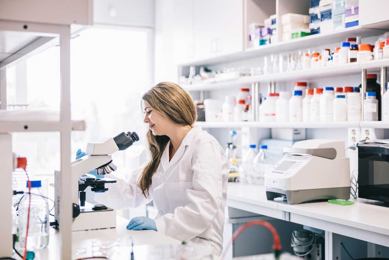A professional scientist in a clean lab environment examining ethically sourced stem cell samples under a microscope at our Colorado Springs, CO treatment center.