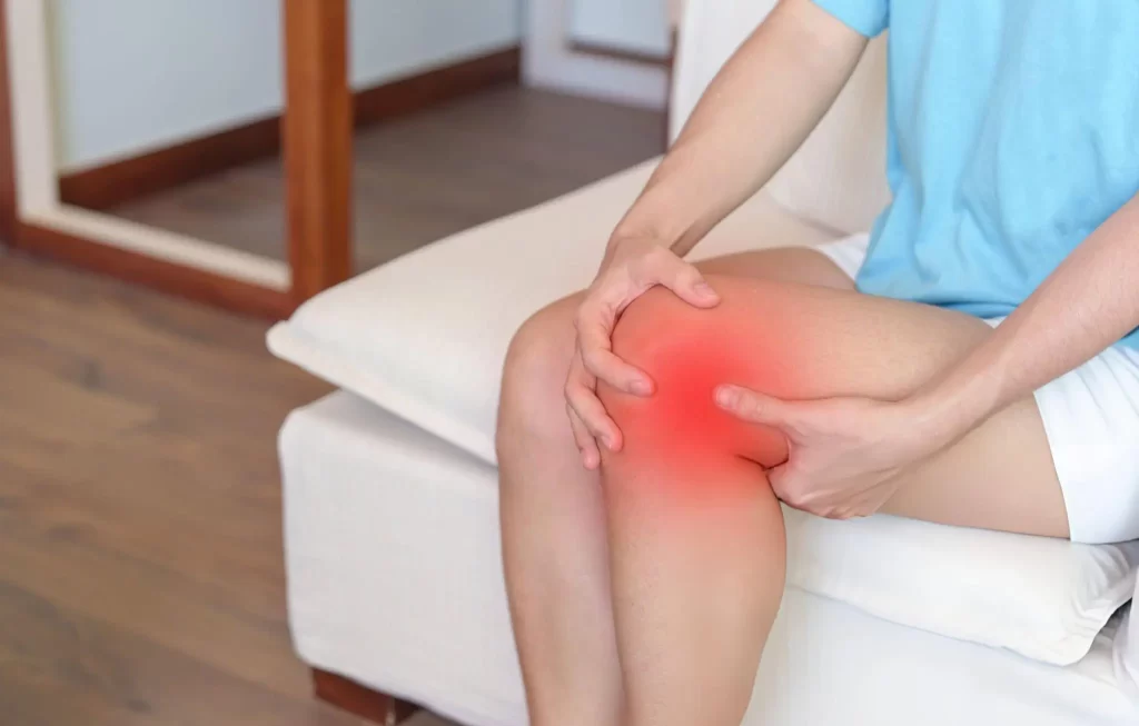 Person holding their inflamed, painful knee — a common reason patients seek regenerative medicine in Milan, Tennessee
