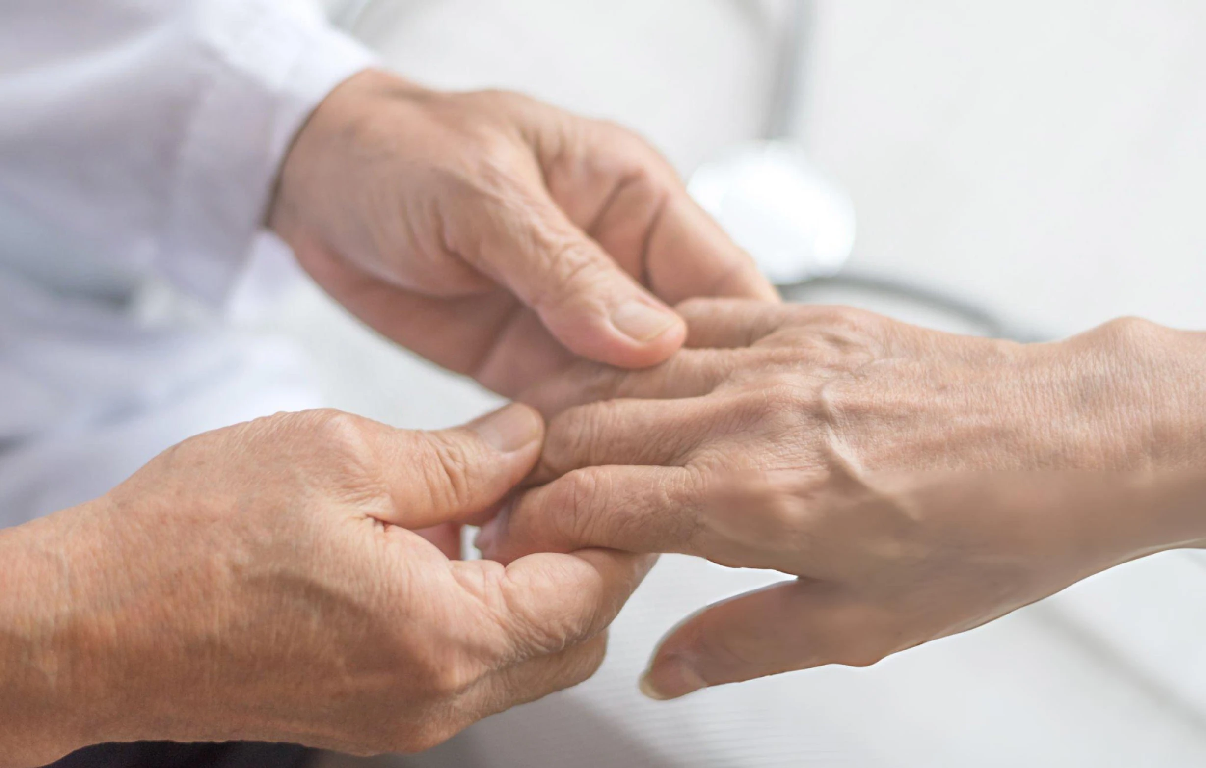 Doctor examining patient hand for peripheral neuropathy symptoms