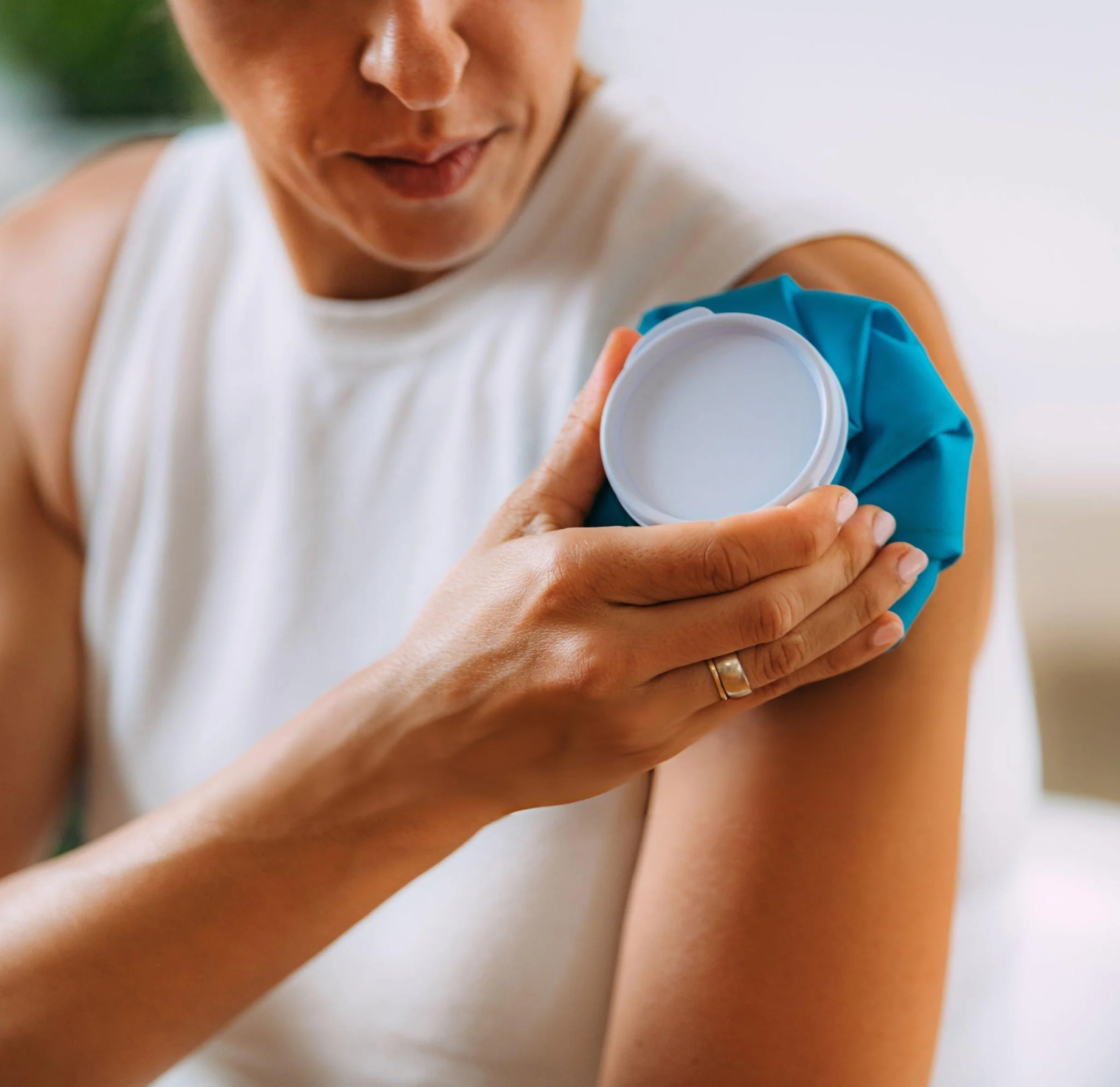 Woman applying ice pack for rotator cuff shoulder pain