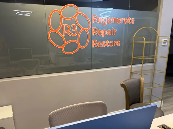 Glass wall at R3 Stem Cell Orlando featuring the R3 logo and the words Regenerate, Repair, Restore