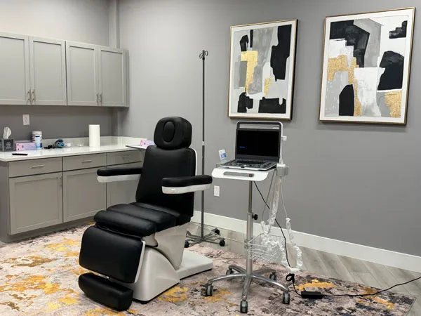 Private treatment room at R3 Stem Cell Orlando with a black treatment chair and modern wall art